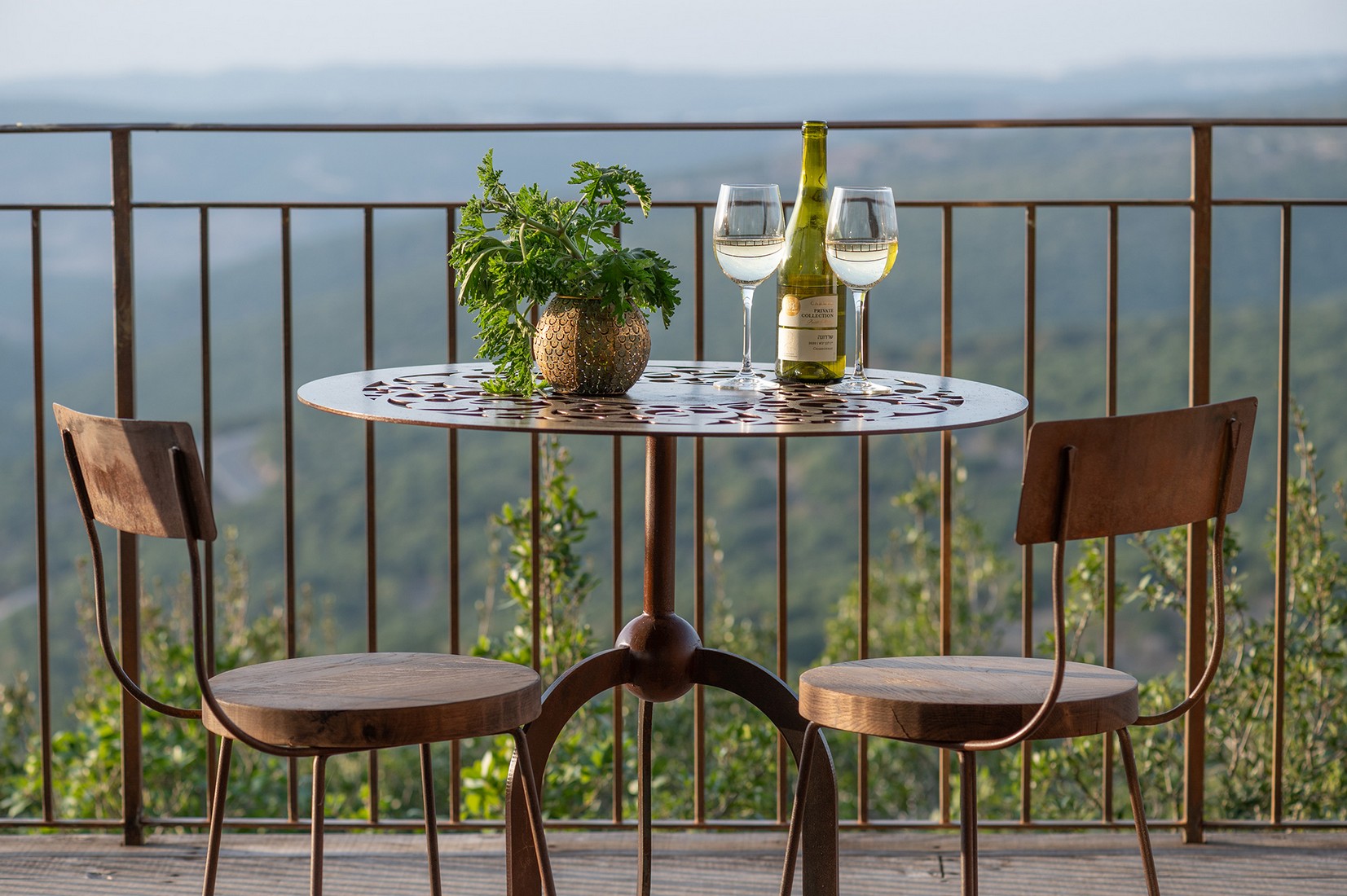 A table and two chairs on the porch facing the view